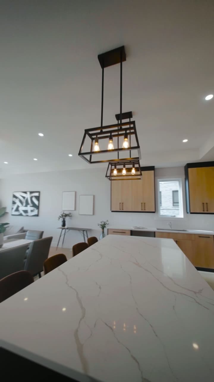 Kitchen island with marble-look countertop and pendant lighting inside the finished Arlington model home