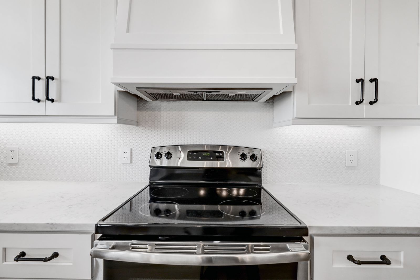 Chef's range wall with custom hood in a completed Carnaby home